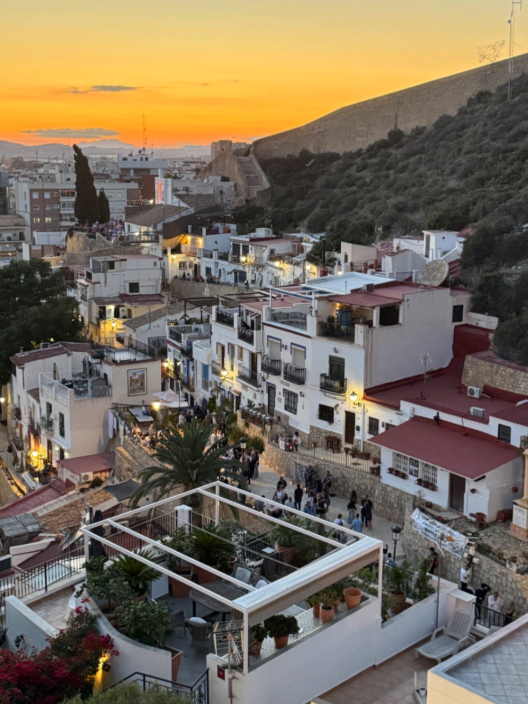Santa Cruz neighbourhood in Alicante at sunset, white houses below the castle